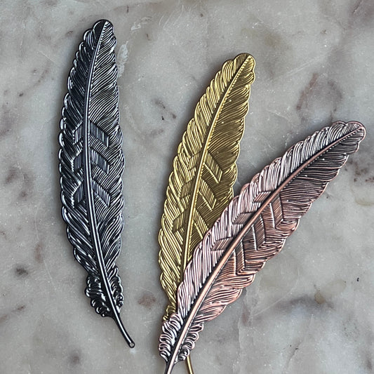 Gold metal feather-shaped bookmark from Copper Crow Swag Market